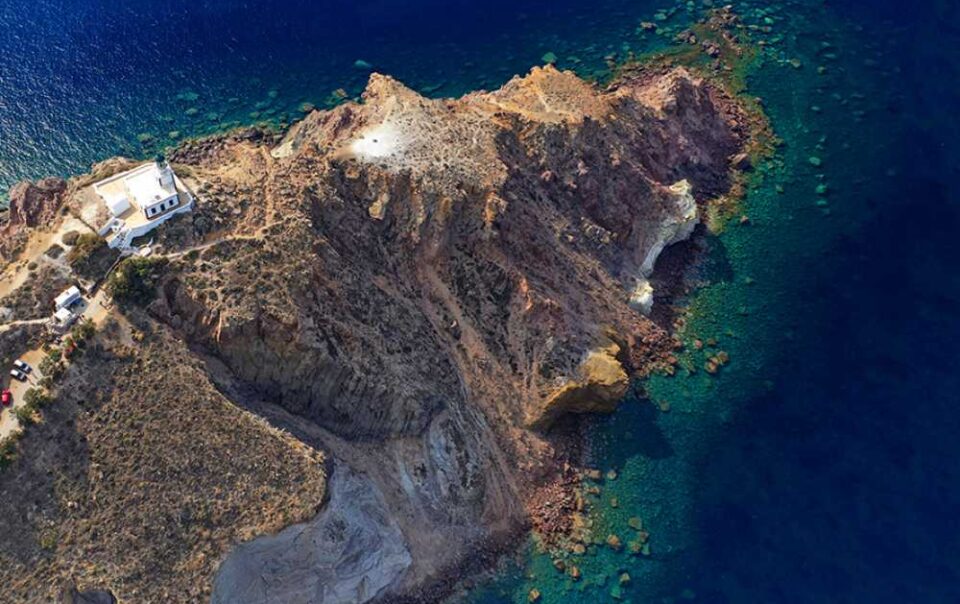 Aerial view of Akrotiri Lighthouse on Santorini’s volcanic cliffs overlooking the Aegean Sea