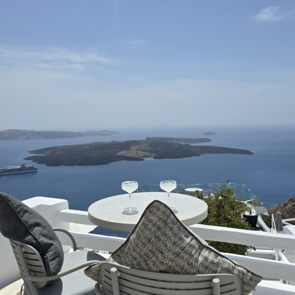 Sunset sea view from On the Rocks Santorini hotel terrace with white lounge chairs