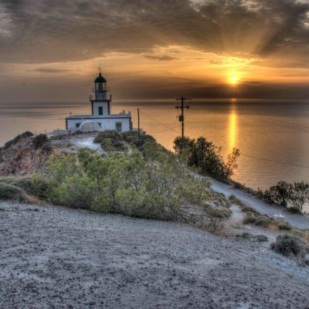 Akrotiri Lighthouse at sunset in Santorini overlooking the Aegean Sea