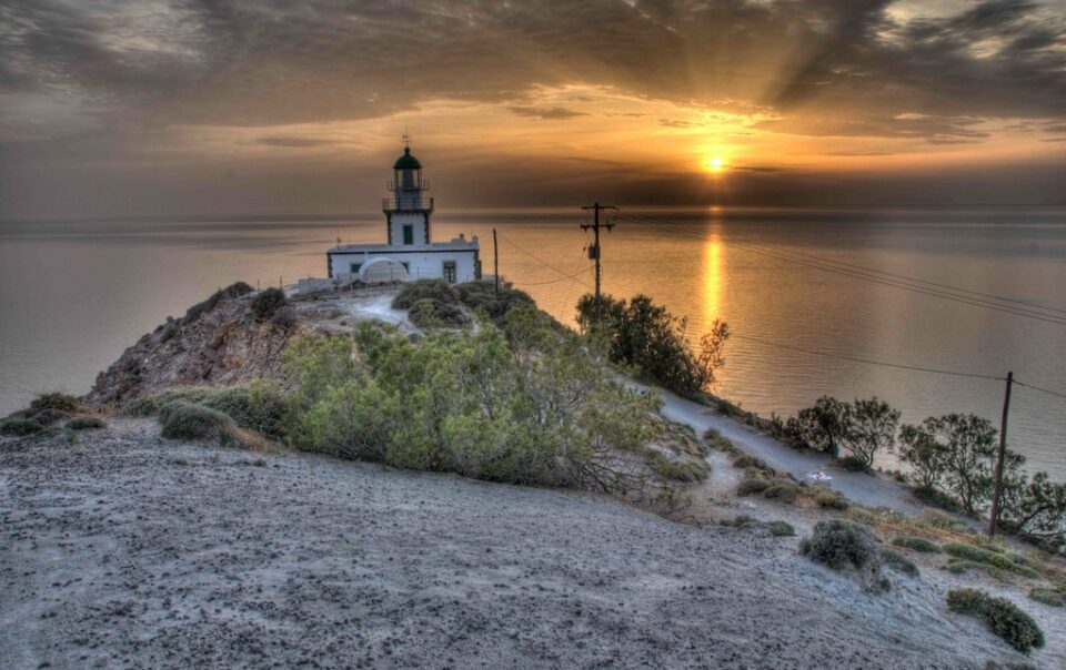 Akrotiri Lighthouse at sunset in Santorini overlooking the Aegean Sea